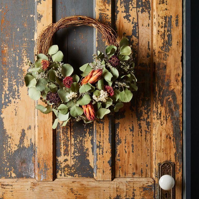 1560868937-fall-door-decor-3e287a22-3f28-472b-827a-6aff2f234f0a-2019-0315-creekside-farms-dried-protea-half-branch-wreath-1x1-rocky-luten-054-1560868928