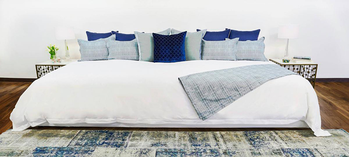 Ace-Collection-12-foot-Bed-with-White-Sheet-and-Blue-Pillows